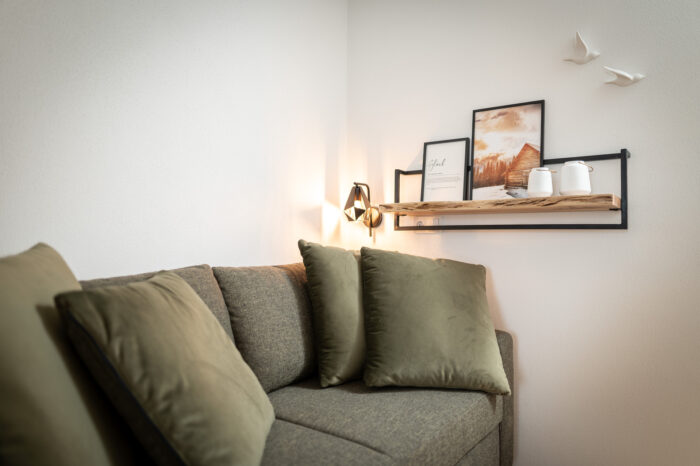 wildbachlodge_appartement 1 Couch mit Wanddekoration im Hintergrund